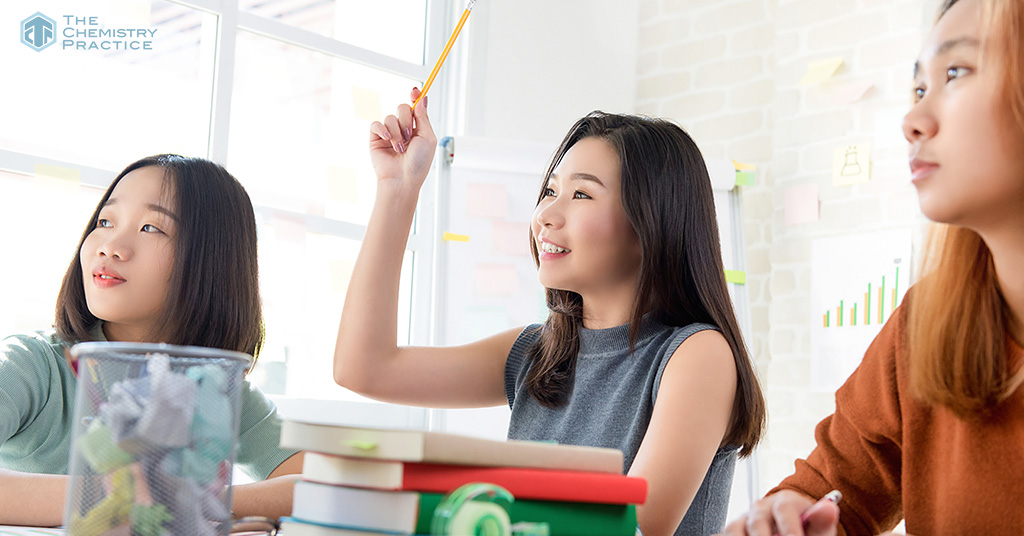 student raising hands in class to ask questions