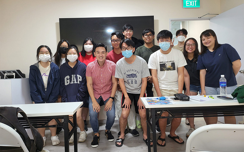 Group of students posing with tutor after chemistry tuition class.
