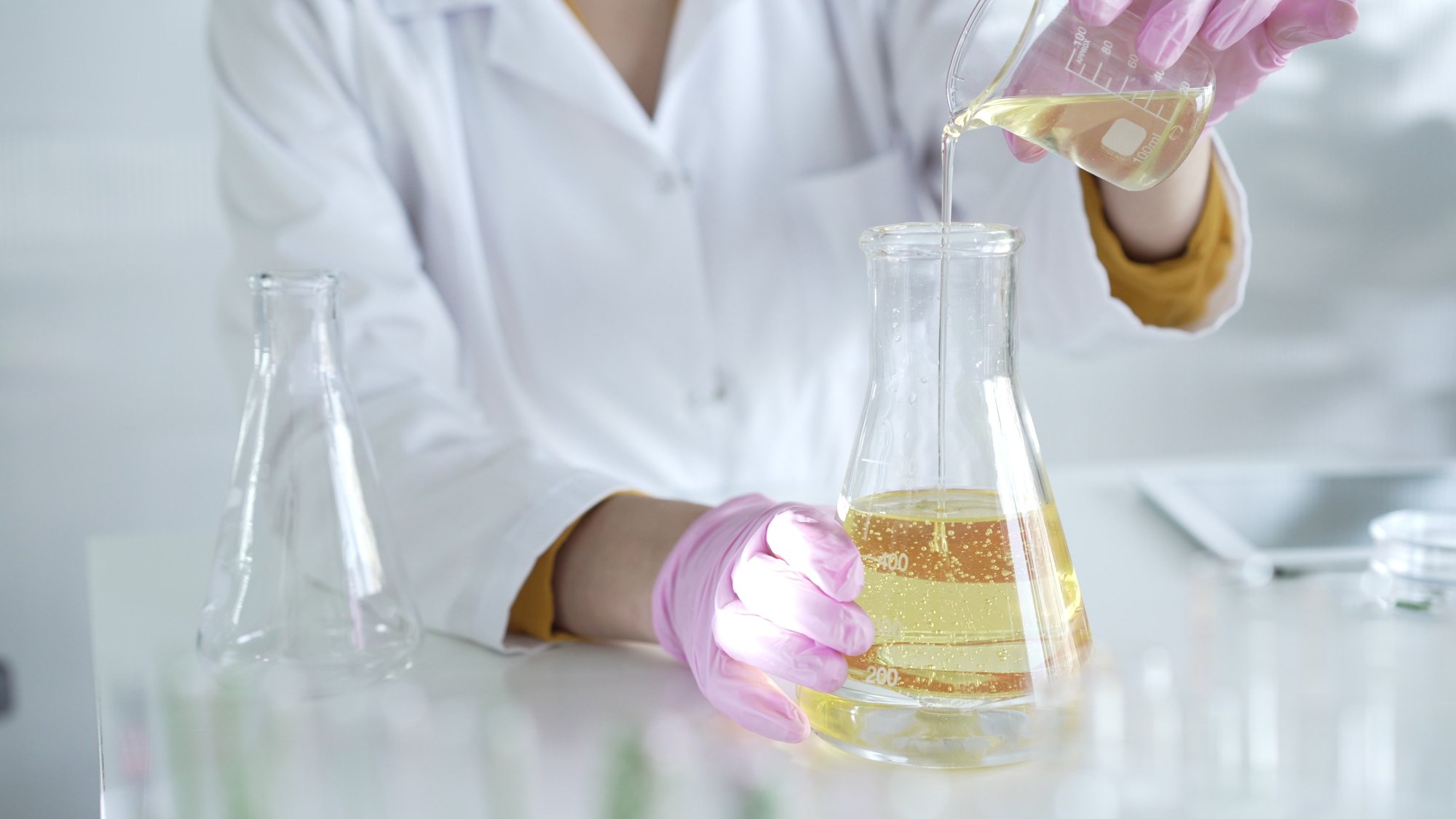 Pouring a chemical solution into a beaker during chemistry practice.